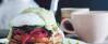 Eggs Benedict aufeinander gestapelt mit Avocado Topping