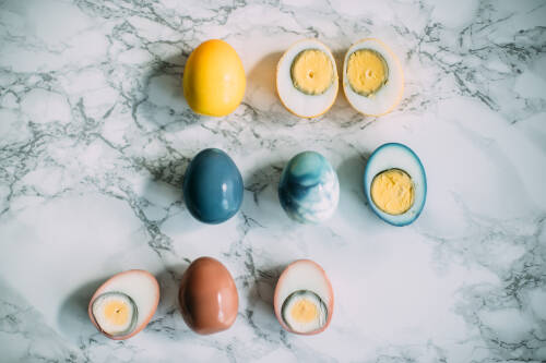 Gelb, blau und rot gefärbte Eier ohne Schale auf Marmor