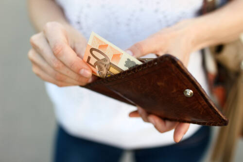 Frau zieht 50 Euro aus Geldbeutel