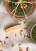 Pesto aus Pinienkernen, Parmesan und Karottengrün in einer Schale auf Holzhintergrund, von oben fotografiert.