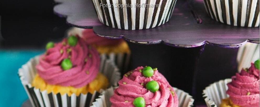 Herzhafte Cupcakes in gestreiftem Förmchen mit pinken Topping und Erbsen als Deko