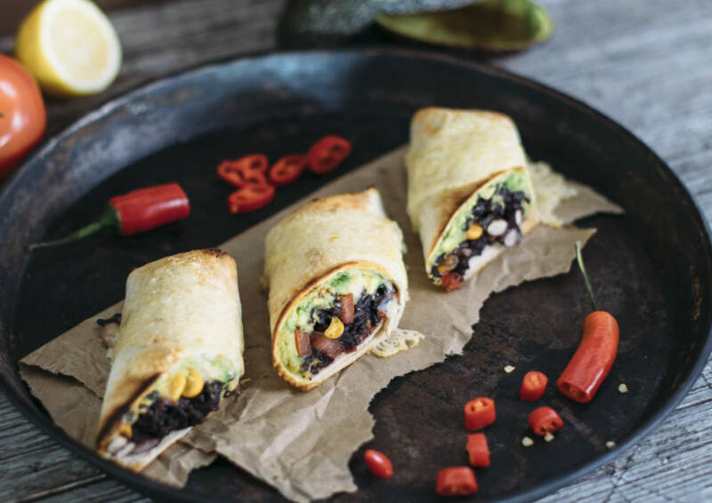 Wenn man mexikanisch Essen will, dann gehören Burritos einfach dazu. Diese hier sind sogar mit Käse überbacken. Drei Stück auf einem Tablett, von oben fotografiert.