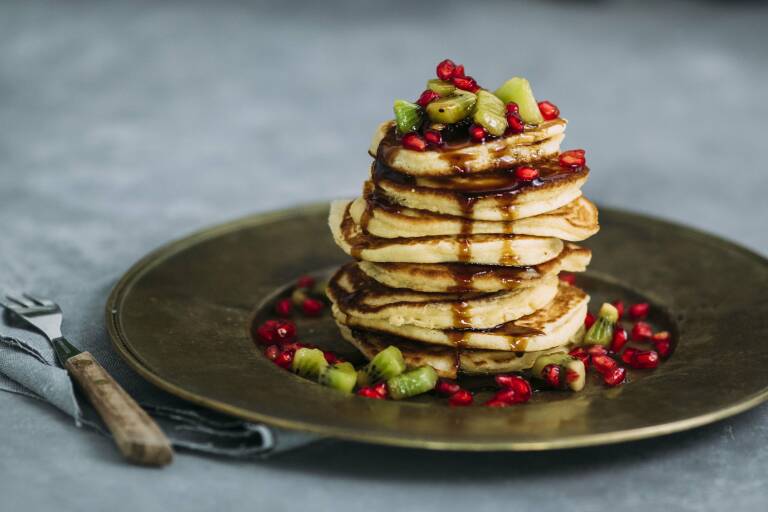 Stapel Pancakes mit Kiwi und Granatapfel