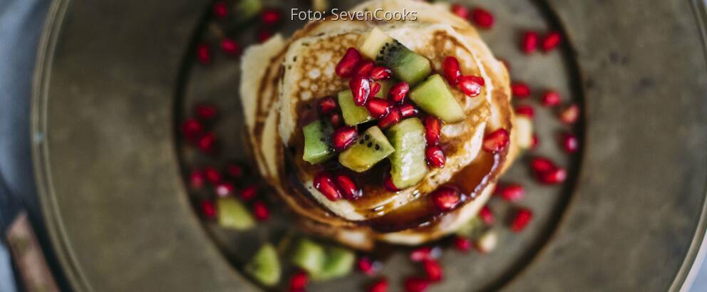 Stapel Pancakes von oben mit Kiwi und Granatapfel