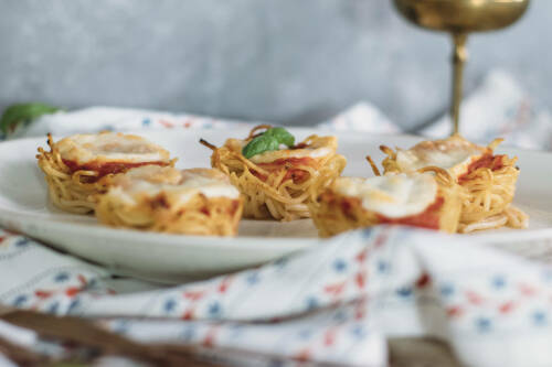 Pasta Frittata Muffins auf weißem Teller vor hellem Hintergrund.