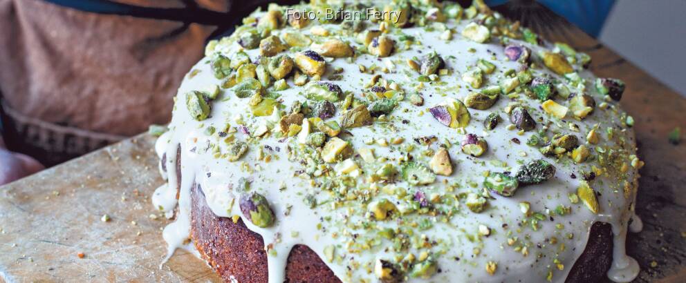 Pistazienkuchen mit weißem Guss und vielen gehackten Pistazien darauf