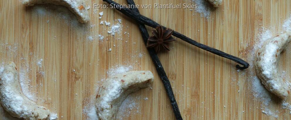 Rohe Vnaillekipferl auf Holzbrett mit Vanilleschote und Sternanis