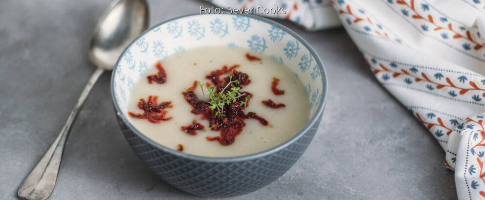 Blaue Schüssel mit Suppe, angerichtet mit Löffel und Rote Bete Einlage