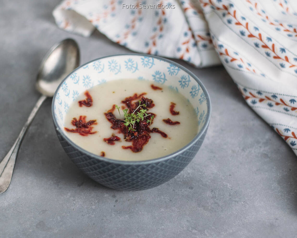 Blaue Schüssel mit Suppe, angerichtet mit Löffel und Rote Bete Einlage