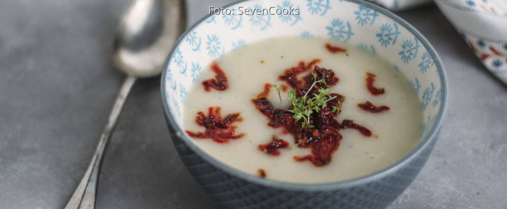 Blaue Schüssel mit Suppe, angerichtet mit Löffel und Rote Bete Einlage