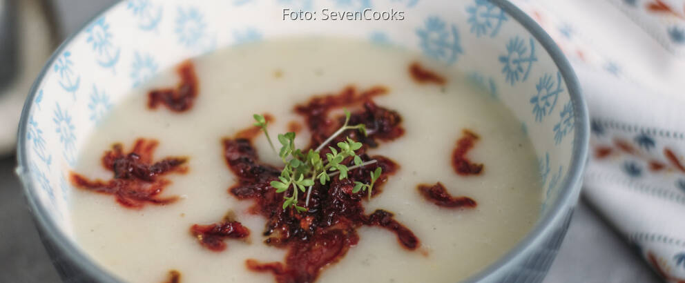 Blaue Schüssel mit Suppe, angerichtet mit Löffel und Rote Bete Einlage