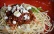Roter Teller mit Spaghetti, sonnengetrockneten Tomaten und zerbröseltem Feta