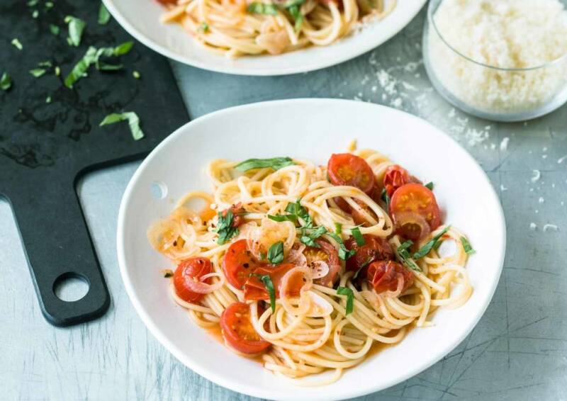 Ein Klassiker: Spaghetti mit Tomaten in leckerem Olivenöl und Knoblauch. Dazu gibt es Parmesan, von oben fotografiert.