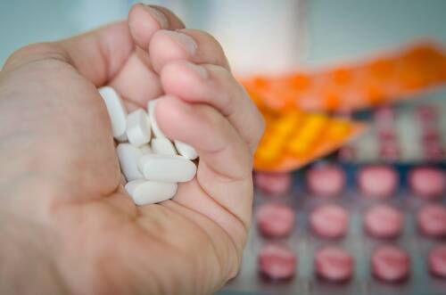 Können Präparate wirklich den Stoffwechsel ankurbeln? In diesem Artikel erfährst du mehr darüber. Zu sehen sind eine Hand voll Tabletten und weitere, volle Blister im Hintergrund.