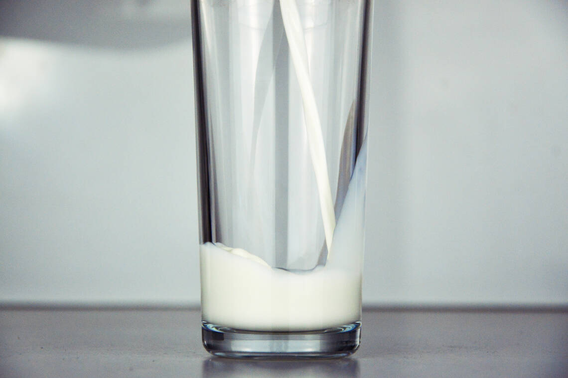 Leckere selbst gemachte Pflanzenmilch aus Nüssen fließt in ein Glas