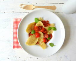 Ein Teller mit veganen Ravioli und Tomatensugo von oben fotografiert