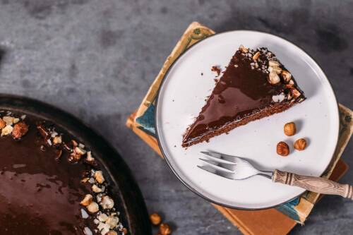 Ein Stück Schokoladenkuchen auf einem weißen Teller von oben.