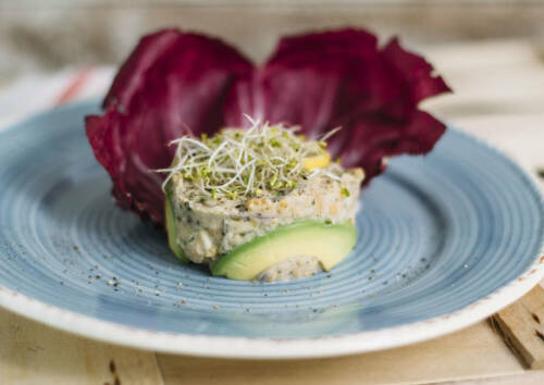 Veganer Thunfischsalat mit Nori-Algen-Flocken, liebevoll auf einem blauen Teller angerichtet.