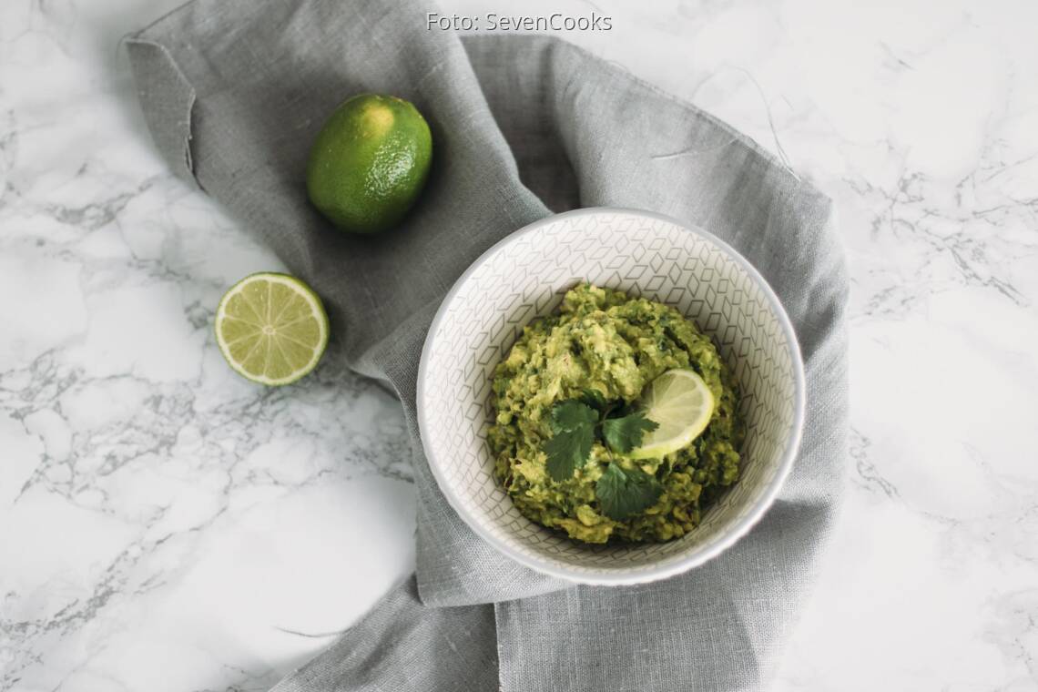 Veganes Rezept: Guacamole mit aufgeschnittener Limette in Schüssel angerichtet