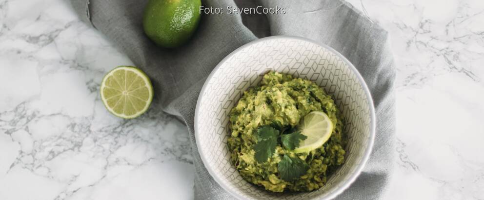 Veganes Rezept: Guacamole mit aufgeschnittener Limette in Schüssel angerichtet