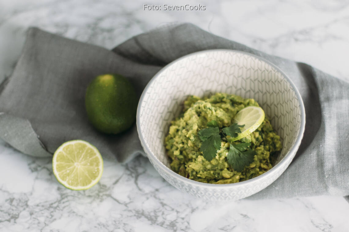 Veganes Rezept: Guacamole mit aufgeschnittener Limette in Schüssel angerichtet