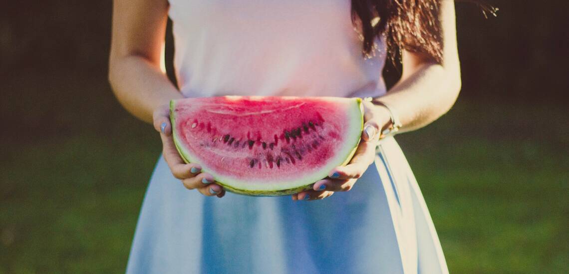 Frau mit einem Viertel Wassermelone in den Händen