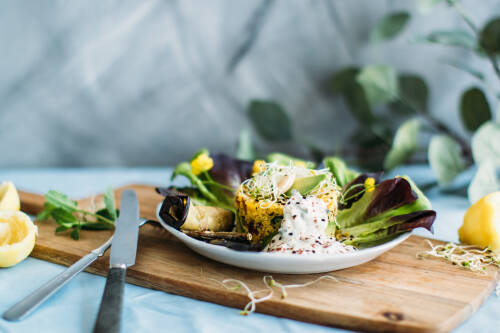 Selbstgemachter Couscous-Salat mit Mandel, Karotte und viel weiterem Gemüse; hübsch angerichtet auf Teller und Holzbrett