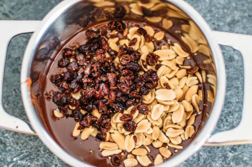 Zubereitung: Die Erdnüsse zusammen mit den Cranberries in den Topf zu geschmolzenen Schokolade geben.